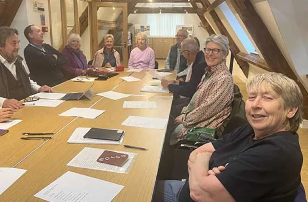 People sat around a table with notebooks and paper in front of them