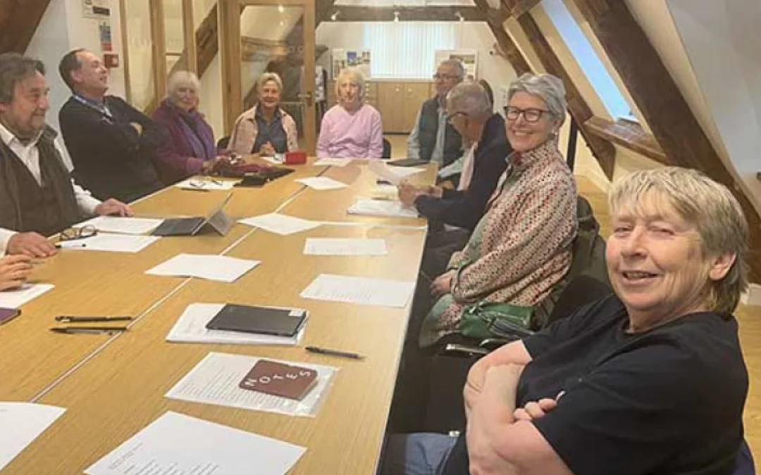 People sat around a table with notebooks and paper in front of them