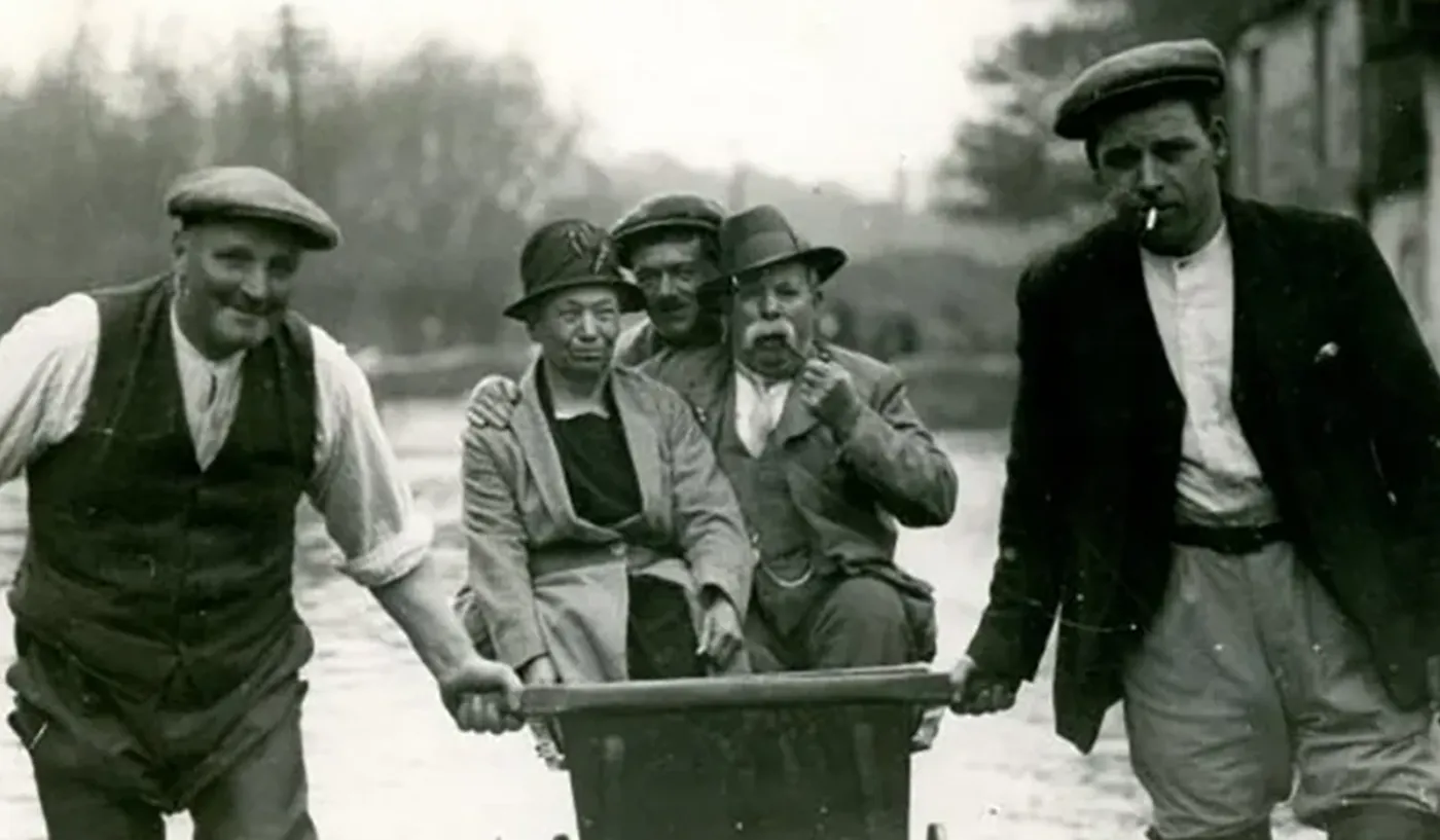 bampton Black and white street party with people sat on benches and deck chairs along multiple tables pushed together