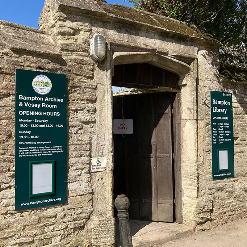 Bampton Archive stone entrance walls with opening times.